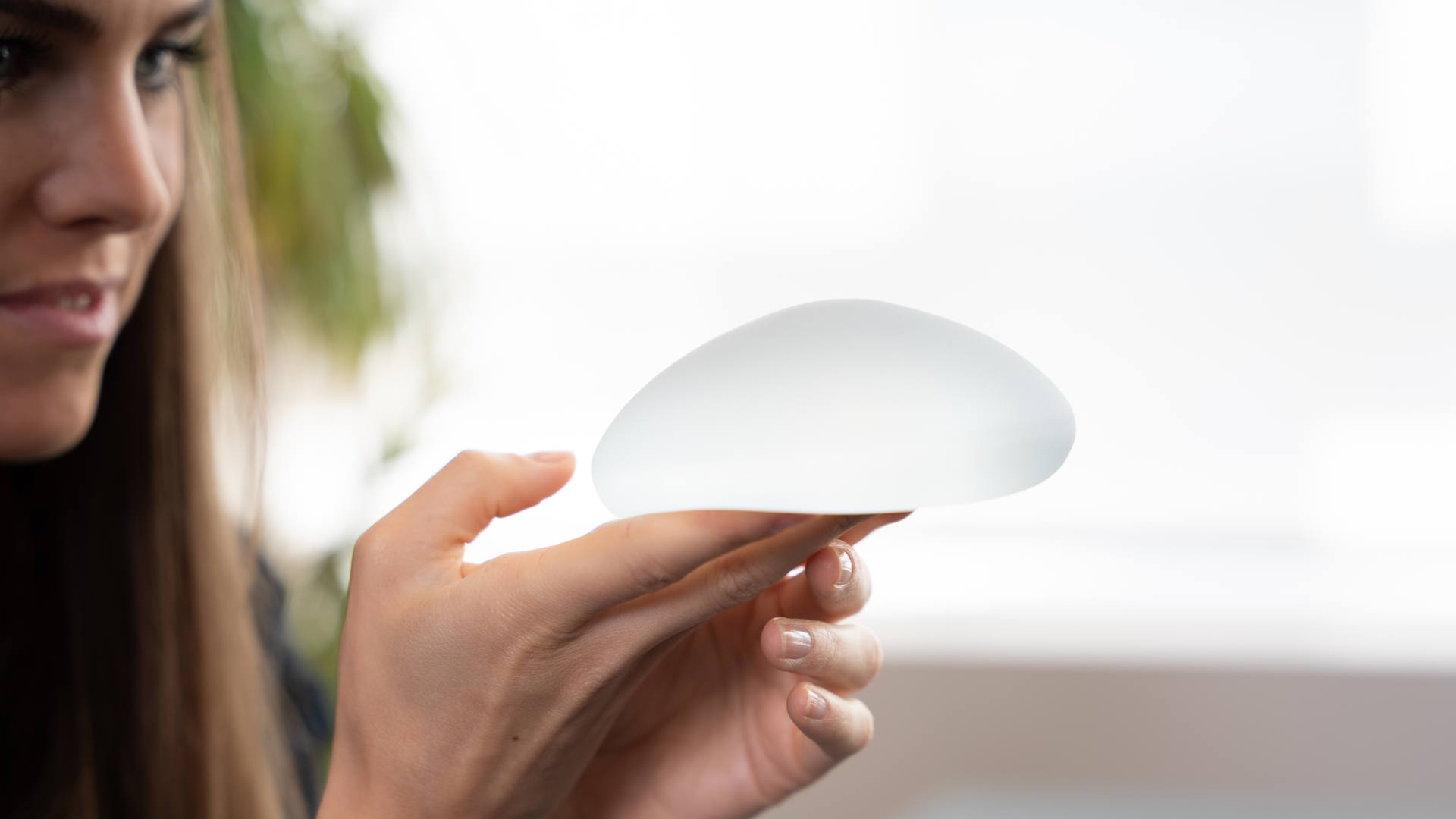 brustimplantate-implantat Motiva Brustimplantat auf der Hand von Patientin.